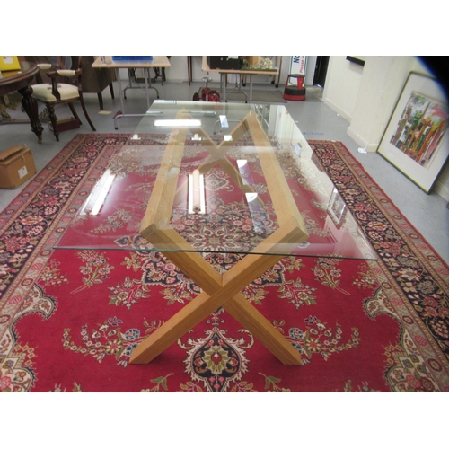 18 - A modern dining table, the glass top set on a light oak, crossover frame  28.5