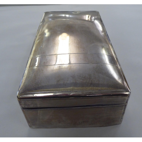 191 - A silver cigarette box with textured decoration and a hinged lid, enclosing a cedar lined interior&n... 