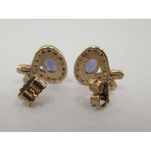 203 - A pair of yellow metal tanzanite and diamond set earrings