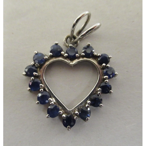 208 - A white metal heart pendant, set with fourteen sapphires