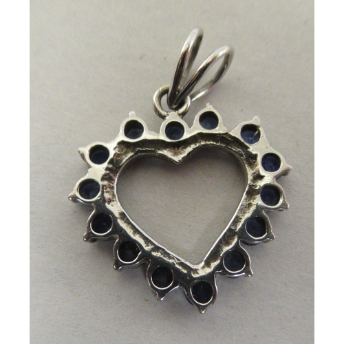 208 - A white metal heart pendant, set with fourteen sapphires