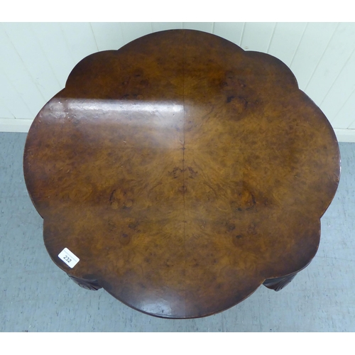 232 - A modern walnut finished occasional table, the serpentine outlined, quarter veneered top over a deep... 