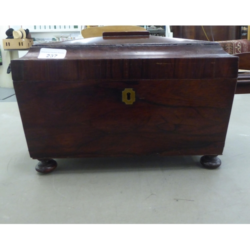 237 - A 19thC rosewood tea casket of sarcophagus form with opposing ring handles, the hinged lid enclosing... 