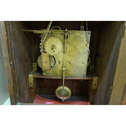 243 - An early 20thC oak cased mantel clock; the chiming movement faced by a silvered and brass Arabic dia... 