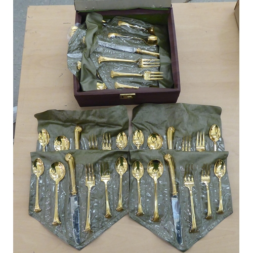 246 - Gilded, stainless steel and other matching flatware, on scrolled and pistol grip handles