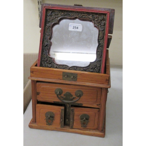 254 - A 20thC Chinese elm vanity box, incorporating a mirror, over three short drawers with brass fittings... 