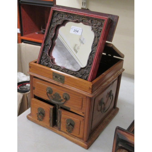 254 - A 20thC Chinese elm vanity box, incorporating a mirror, over three short drawers with brass fittings... 