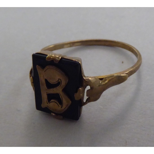 270 - A Bulova gold coloured metal ring, set with a black tablet and initial 'B'