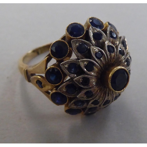 272 - A gold coloured metal ring, set with graduated three tiered sapphires  stamped 14k