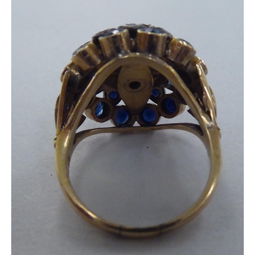 272 - A gold coloured metal ring, set with graduated three tiered sapphires  stamped 14k