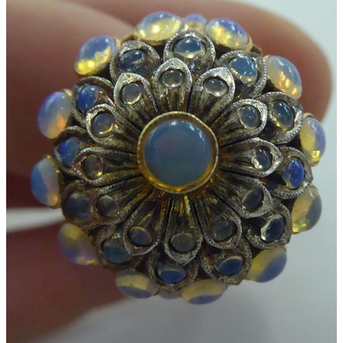 273 - A gold coloured metal ring, set with a graduated three tiers of opals   stamped 14k