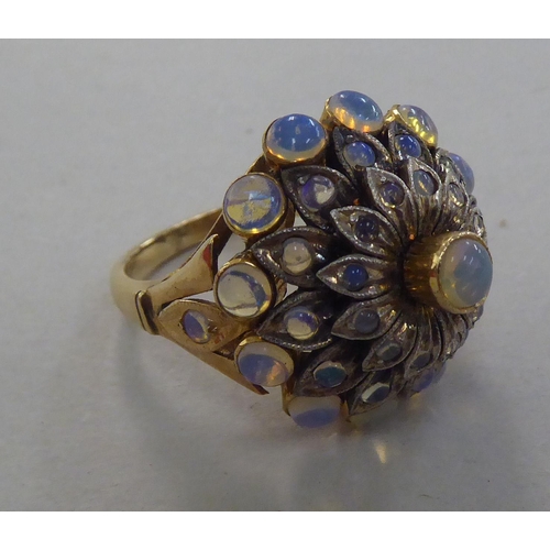 273 - A gold coloured metal ring, set with a graduated three tiers of opals   stamped 14k