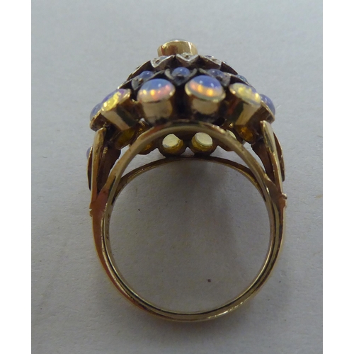 273 - A gold coloured metal ring, set with a graduated three tiers of opals   stamped 14k