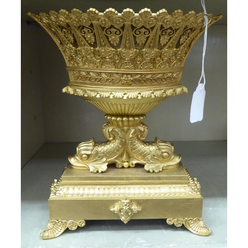 278 - A 20thC cast gilt metal table centrepiece, the pierced oval bowl elevated on back-to-back fish, on a... 