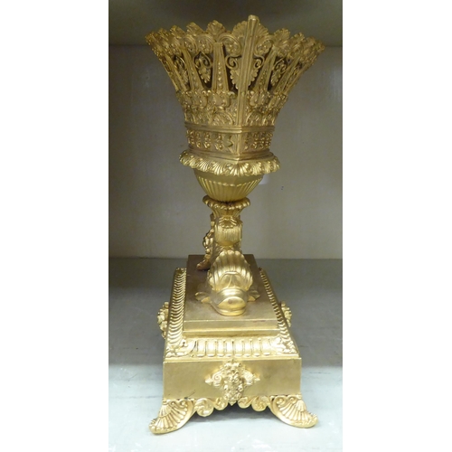 278 - A 20thC cast gilt metal table centrepiece, the pierced oval bowl elevated on back-to-back fish, on a... 