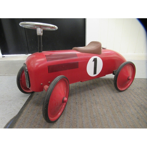 285 - A replica of a vintage red, white and black painted metal ride-on racing car