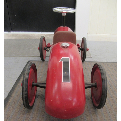 285 - A replica of a vintage red, white and black painted metal ride-on racing car