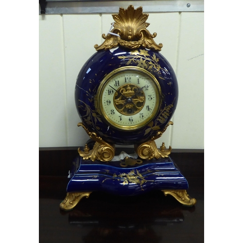 68 - An early/mid 20thC midnight blue china and gilded mantel timepiece with gilt metal mounts; the movem... 