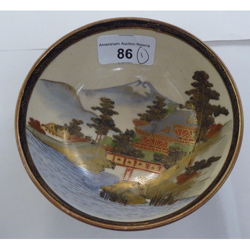 86 - An early/mid 20thC Japanese Satsuma earthenware bowl, traditionally decorated with a landscape and g... 