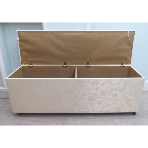 48 - A modern cream coloured fabric upholstered ottoman with straight sides and a cushioned, hinged seat,... 