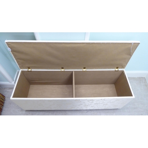 48 - A modern cream coloured fabric upholstered ottoman with straight sides and a cushioned, hinged seat,... 