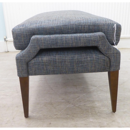 58 - A modern blue fabric upholstered, cushioned, window seat, raised on square, tapered legs  55