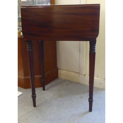 51 - A mid Victorian mahogany Pembroke table with a hinged flap and a fall flap on the obverse, raised on... 