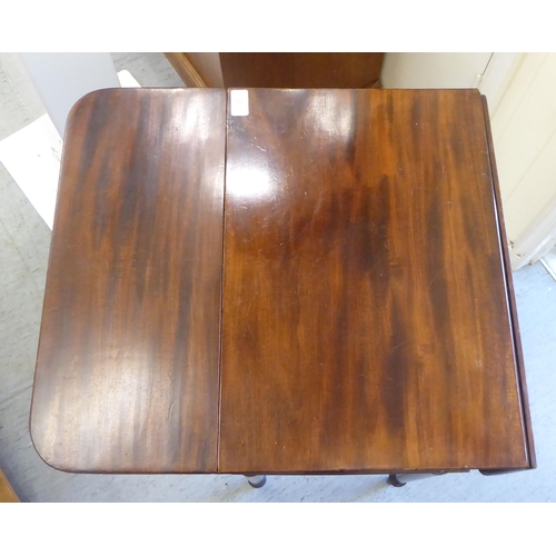 51 - A mid Victorian mahogany Pembroke table with a hinged flap and a fall flap on the obverse, raised on... 