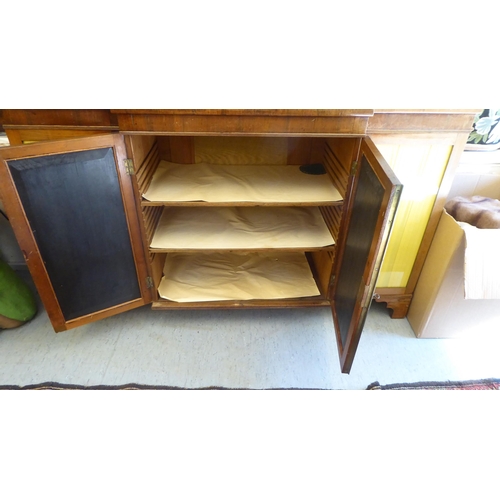 9 - A Regency rosewood and mahogany breakfront sideboard with four glazed doors, raised on bracket feet ... 