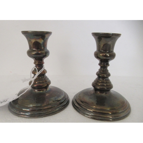 105 - A pair of Sterling silver candlesticks, each on a loaded base  4.5