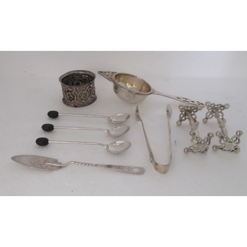 108 - Silver collectables: to include a pair of knife rests, a tea strainer and a napkin ring  mixed ... 