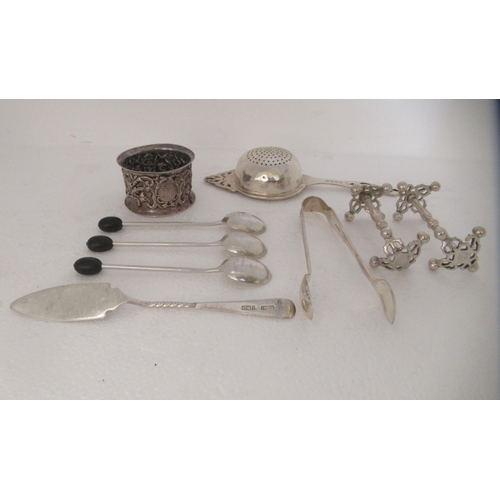 108 - Silver collectables: to include a pair of knife rests, a tea strainer and a napkin ring  mixed ... 