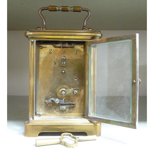 125 - A mid 20thC brass cased carriage timepiece with bevelled glass panels and a folding top handle; the ... 