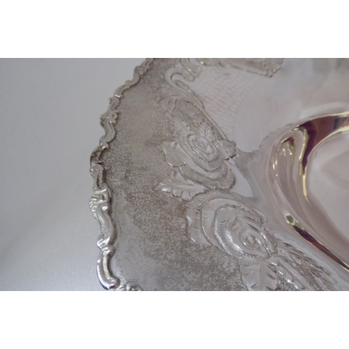 151 - A Continental silver coloured metal fruit dish, the wide, flared, embossed and chased, floral patter... 