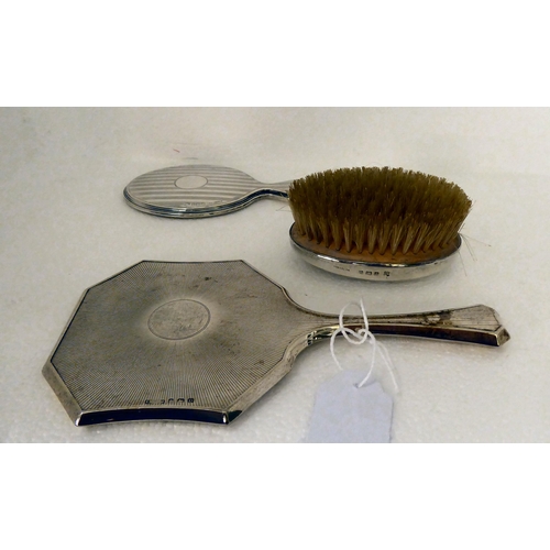 161 - A child's silver backed hairbrush and hand mirror  Birmingham 1926  cased; and another mir... 