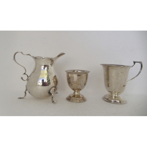 167 - Silver tableware: to include a tea strainer and bowl; a toddy cup; and a cream jug  mixed marks