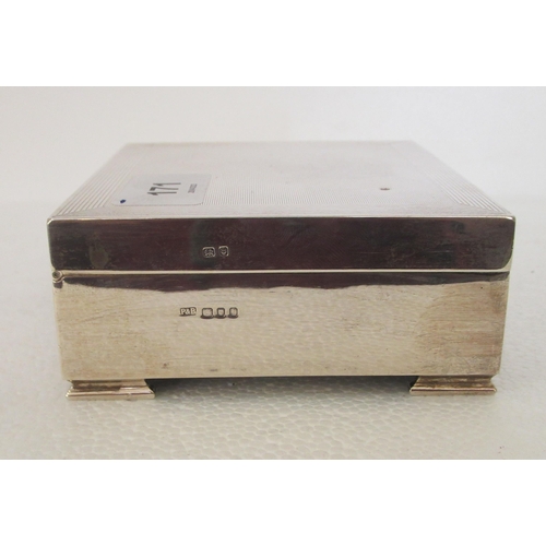 171 - A silver square cigarette box with engine turned decoration and a hinged lid, enclosing a cedar line... 