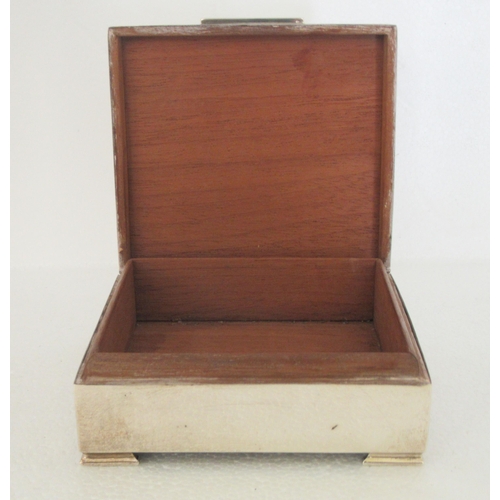 171 - A silver square cigarette box with engine turned decoration and a hinged lid, enclosing a cedar line... 