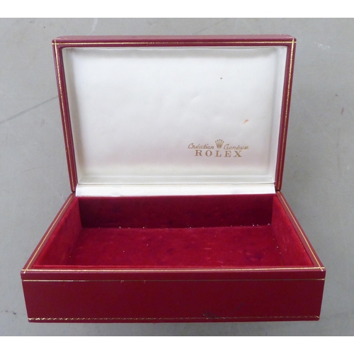 174 - A Rolex tooled and gilded red hide presentation box, the hinged lid set with an embroidered panel, f... 