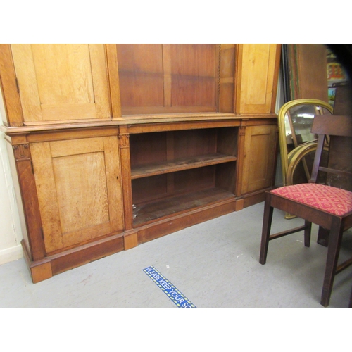 217 - A mid Victorian oak library bookcase, comprising a central section of seven open shelves, flanked by... 