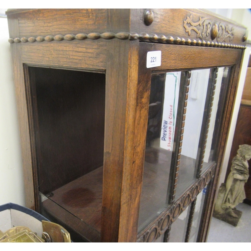 221 - A 1930s oak display cabinet with a single astragal glazed door, raised on bulbous turned legs and bl... 