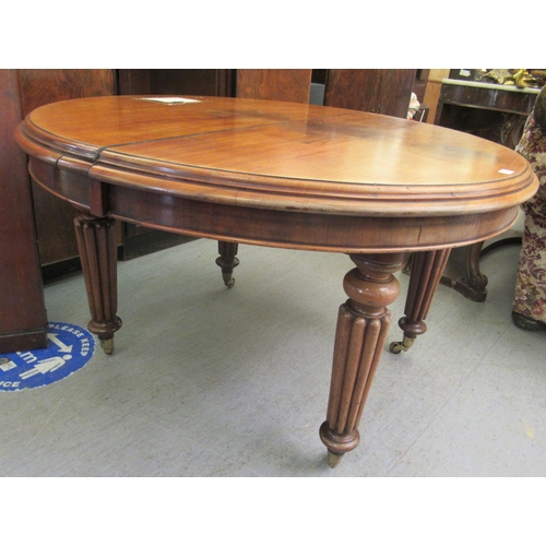 226 - A late Victorian mahogany, oval, wind-out dining table, raised on turned, tapered, reeded legs and c... 