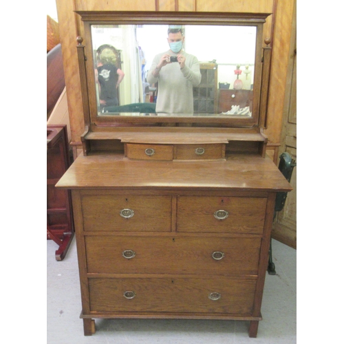 227 - A 1930s Arts & Crafts inspired oak dressing table, the bevelled mirror pivoting on square horns,... 