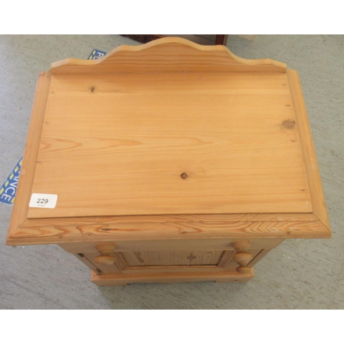 229 - A modern pine bedside cabinet with a drawer and a door, on a plinth  24