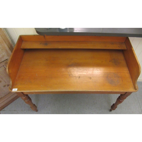 234 - A late Victorian pine and oak washstand with a raised upstand, raised on turned, tapered legs  ... 