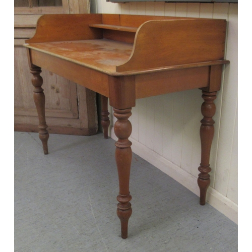 234 - A late Victorian pine and oak washstand with a raised upstand, raised on turned, tapered legs  ... 