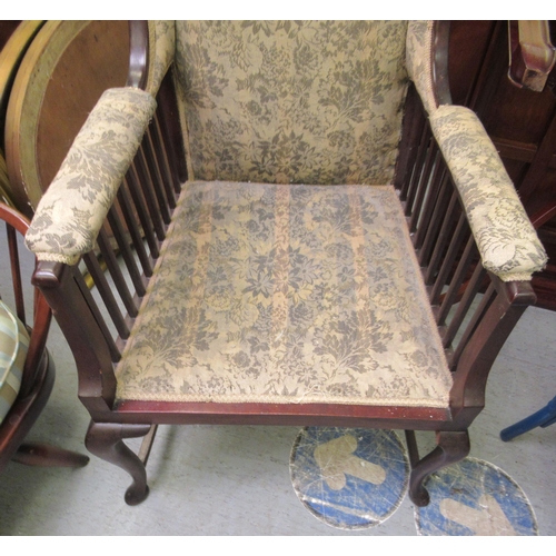 237 - An Edwardian mahogany framed porter style chair, upholstered in a flora fabric, raised on cabriole l... 