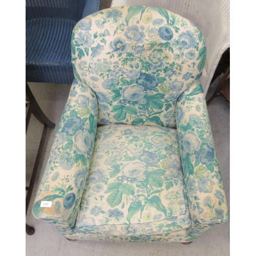 240 - An Edwardian mahogany framed salon chair with a floral fabric upholstered back and seat, raised on m... 