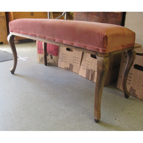 241 - An early 20thC stained beech framed duet stool with a pink fabric upholstered top, raised on cabriol... 