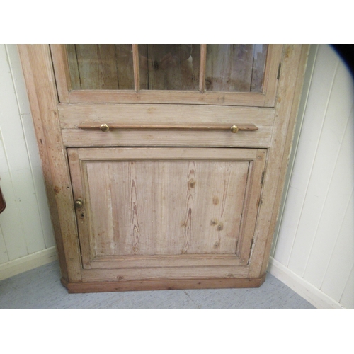 247 - A late Victorian pine corner cabinet with a dentil moulded cornice, over an astragal glazed door, a ... 